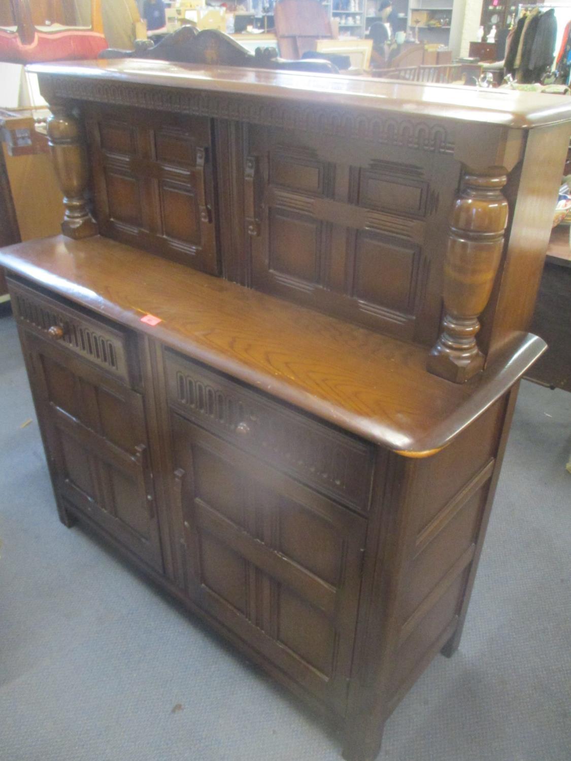 A mid 20th century dark elm court cupboard having four cupboard doors and twin drawers, 49" h x 47