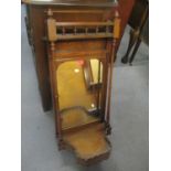 A late Victorian walnut wall hanging mirror having twin columns and shelf below, 34 1/2"h x 14 1/2"w