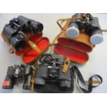 Three binoculars cased and another set