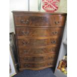An early 20th century mahogany serpentine fronted six drawer chest of drawers, standing on bracket