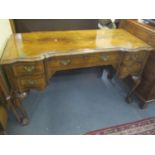 An early 20th century walnut side table having one long drawer flanked by four short drawers,