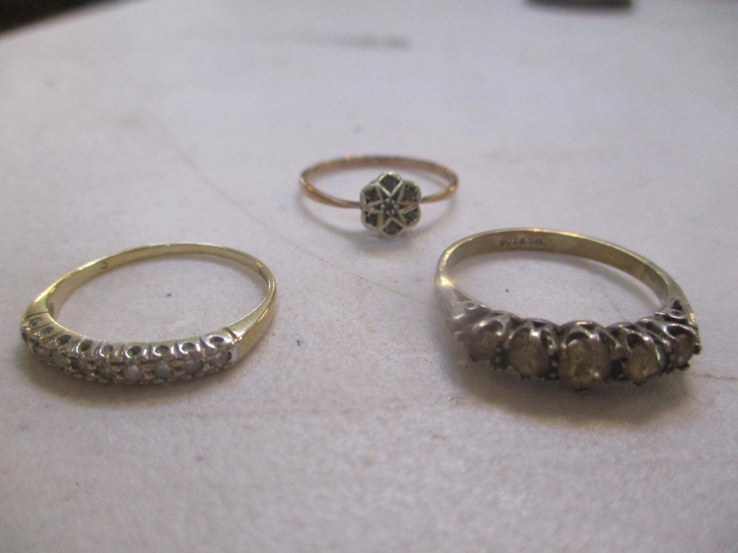 Three 9ct gold rings to include a daisy ring