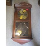 An early 20th century oak wall clock fitted with an 8 day movement, brass dial with Arabic numerals