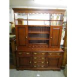 A modern Stewart Linford oak dresser having a plate rack above cupboards and drawers, 76"h x 58 1/