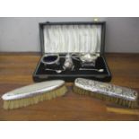 A silver condiment set, boxed, together with two silver and white metal backed brushes