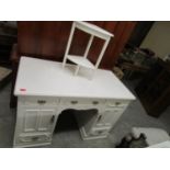 An early 20th century white painted pedestal desk, three frieze drawers above twin cupboard doors
