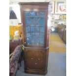 A Georgian mahogany corner cabinet having a dental moulded cornice above an astragal glazed door and