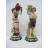 A pair of Bernhard Bloch figures of a woman carrying a vase and a man carrying a basket, each on a