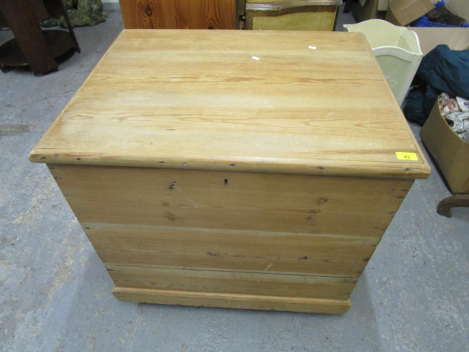 A pine storage trunk with iron carrying handles, hinged lid, on plinth base and wheels Location: G