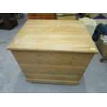 A pine storage trunk with iron carrying handles, hinged lid, on plinth base and wheels Location: G