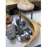 A Pentax Asahi K1000 camera in case with lens and accessories, a wooden stool, and a French cane and