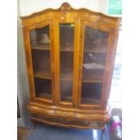 A modern French style walnut finished display cabinet having two glazed doors above six drawers