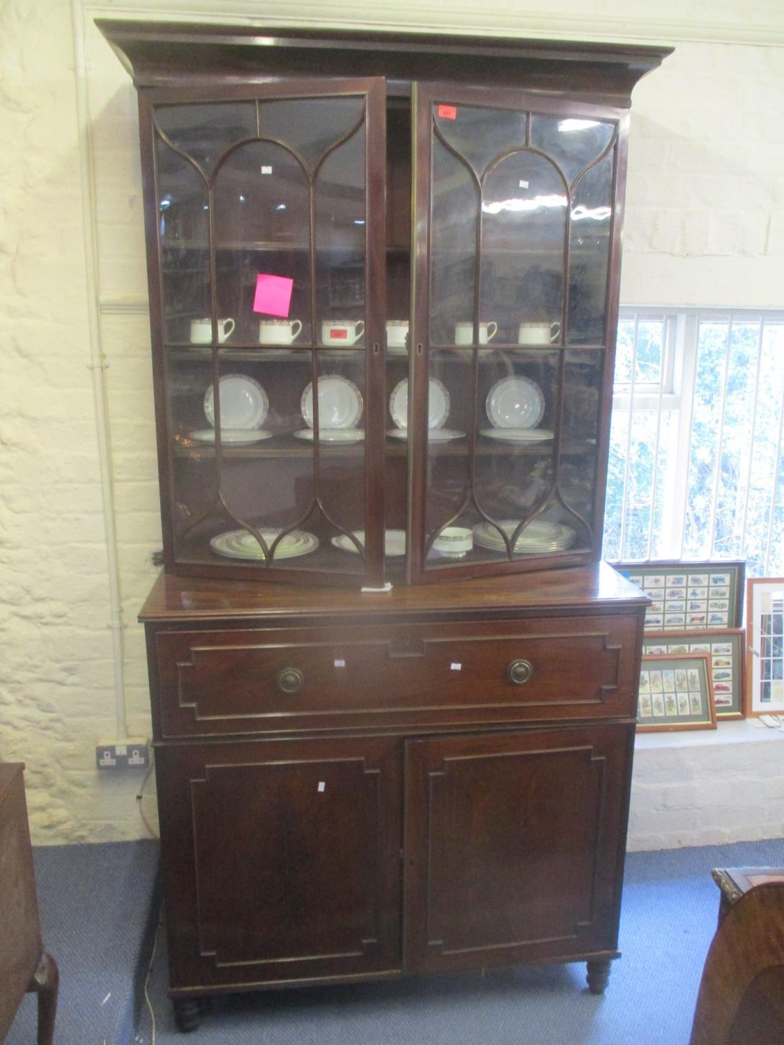 An early 19th century mahogany secretaire bookcase, having twin glazed doors above a fall flap