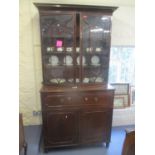 An early 19th century mahogany secretaire bookcase, having twin glazed doors above a fall flap