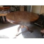 A Victorian mahogany tip top dining table with a carved column end splayed legs