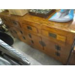 An oriental hardwood sideboard having four short drawers above four cupboard doors, standing on