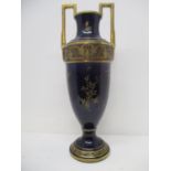 A late 19th century continental blue glazed urn with twin handles and a tapered body, on a