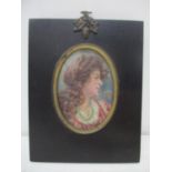 An Edwardian portrait miniature, the head and shoulders of a woman with long brown wavy hair,