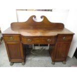 A Regency, possibly Irish mahogany sideboard with a swan neck upstand, a central curved fronted