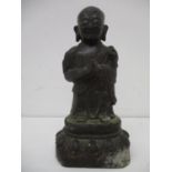 An antique Chinese bronze figure of a praying monk on a single lotus base, 6 7/8"h