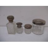 Four glass dressing table bottles, one with a tortoiseshell top, the other with silver, various