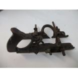 An early 20th century Stanley No 45 combination plane with a wooden handle and cast leaf ornament