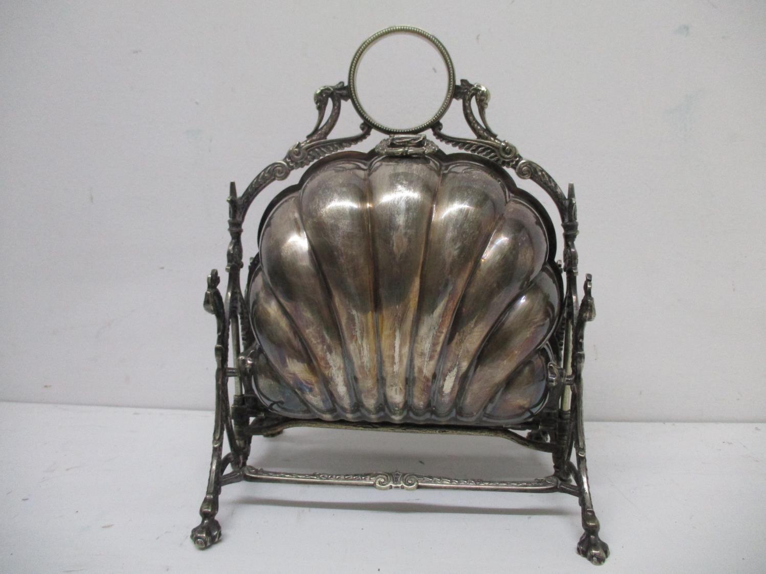 A Victoria silver plated biscuit box with a ring, bird head and scrolled handle, over twin scalloped