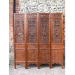 A 20th century Chinese elm four fold screen, with carved and pierced panels, decorated with animals,