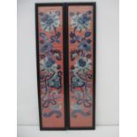A pair of early 20th century Chinese silk embroidered panels, with flowers in tones of blue on a
