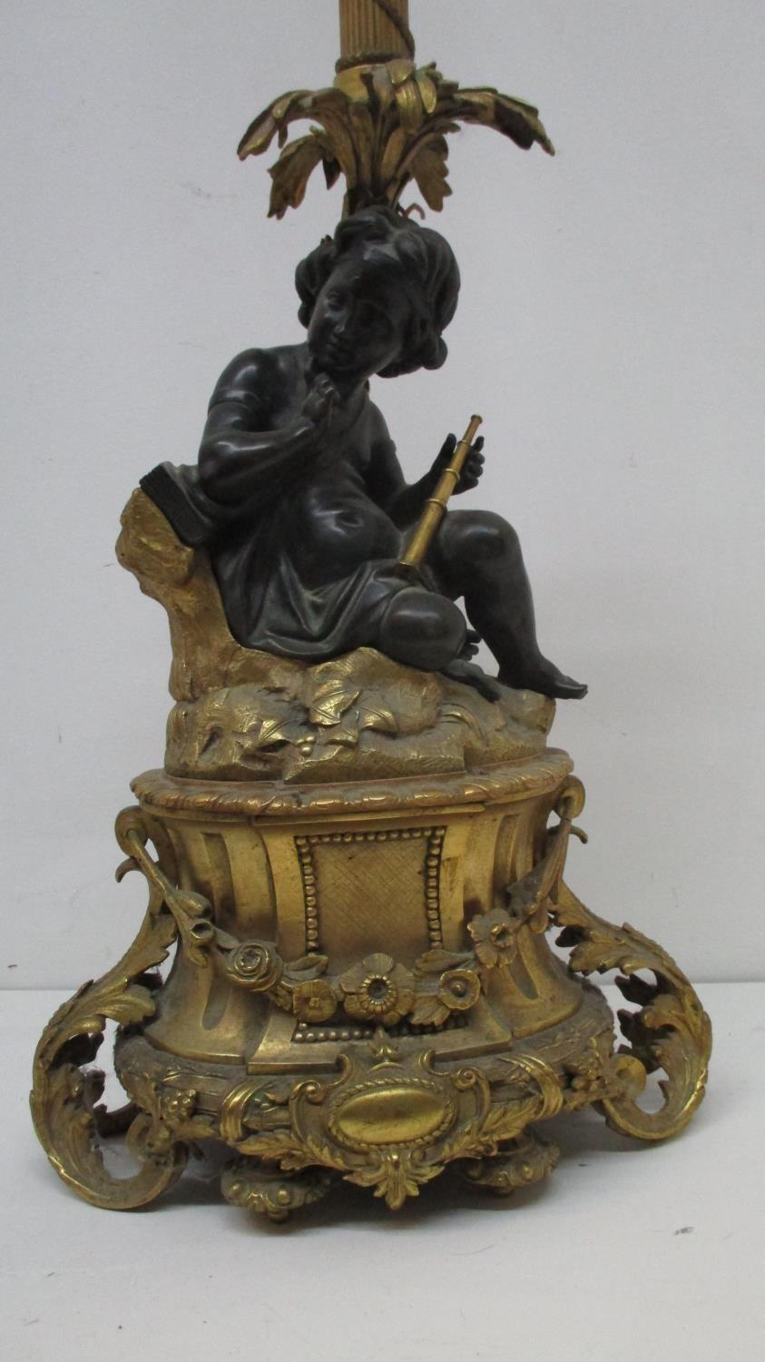 A late 19th century gilt and patinated bronze lamp base, fashioned as a young girl holding a