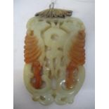 A late 19th/early 20th century two tone, brown jade pendant carved and pierced with two birds, on