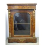 A late Victorian walnut pier cabinet with gold painted metal mounts and floral marquetry, the