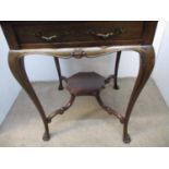 A Victorian walnut envelope table with a rotating top over a drawer, on cabriole legs and paw