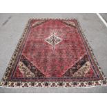 A North West Persian carpet with a central medallion and geometric boteh, flowers and motifs on a