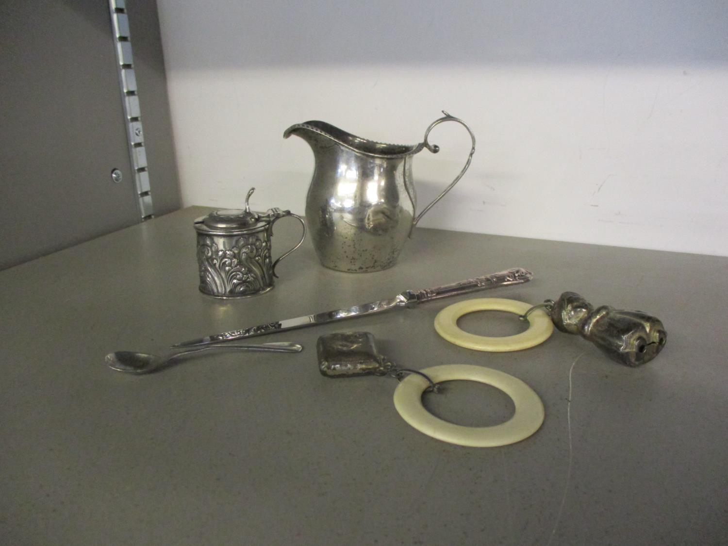 A mixed lot of silver items to include a milk jug and mustard pot and babies rattles.Location:Port - Image 2 of 3