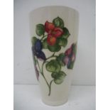 A Moorcroft pottery vase of cylindrical, tapered form decorated with a stem of flowers and foliage