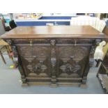 A Victorian carved pussy oak side cabinet, two drawers with brass drop handles over two cupboard