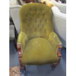 A Victorian walnut button back salon armchair having turned legs and castors