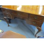 A 1930s quarter cut, walnut veneered dressing table, the central drawer flanked by four graduated