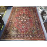 A Middle Eastern red ground rug having a central motif, multi-guard borders and tasselled ends,