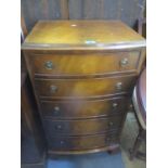 A reproduction flamed mahogany tallboy with five graduated drawers on ogee bracket feet, 36 1/2"h