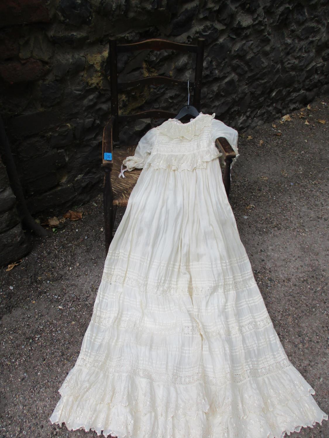 An early 20th century rush seated child's chair and christening gown