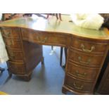 A reproduction walnut serpentine fronted, twin pedestal desk having a green leather topped scriber