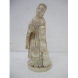 A late 19th century Japanese carved ivory figure of a woman wearing a kimono, leaning against a tree