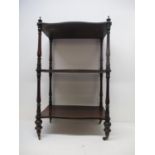 A Victorian rosewood serpentine fronted whatnot with a gallery, three tiers and turned columns on