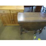 A 1930s oak drop leaf table with barleytwist supports, a small pine bookcase and a modern oak