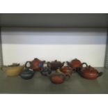 A collection of nine Chinese Yixing Zisha teapots, some in the form of fruit