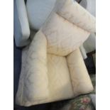 A rocker armchair having a cream damask fabric
