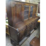 A large mid 20th century oak sideboard having a raised top with cupboard and glass doors above