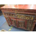 A near pair of 19th/20th century Chinese red lacquered cabinets with profusely carved ornament, with